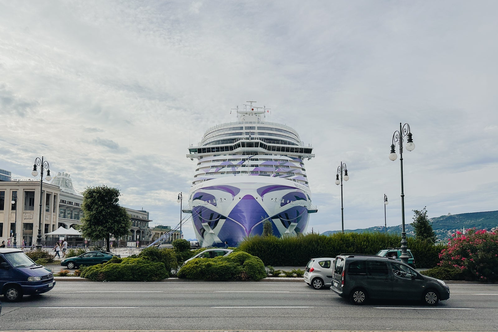 A cruise ship docked in Trieste, Italy, with the appearance that it's sailing toward a nearby street