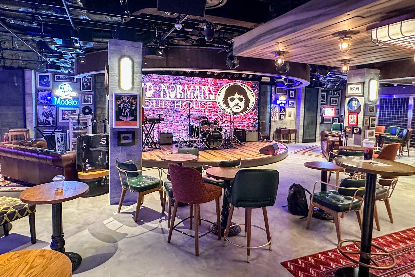 A rock 'n' roll performance venue and bar on a cruise ship with a stage, tables and chairs