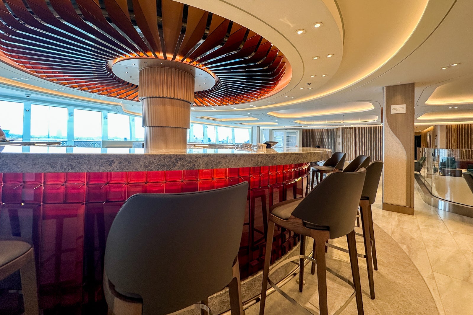 A round whiskey bar surrounded by chairs on a cruise ship