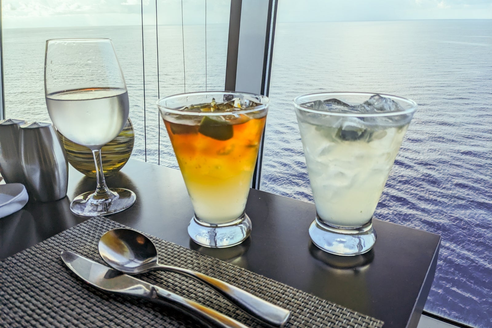 Two cocktails by a window looking out to sea