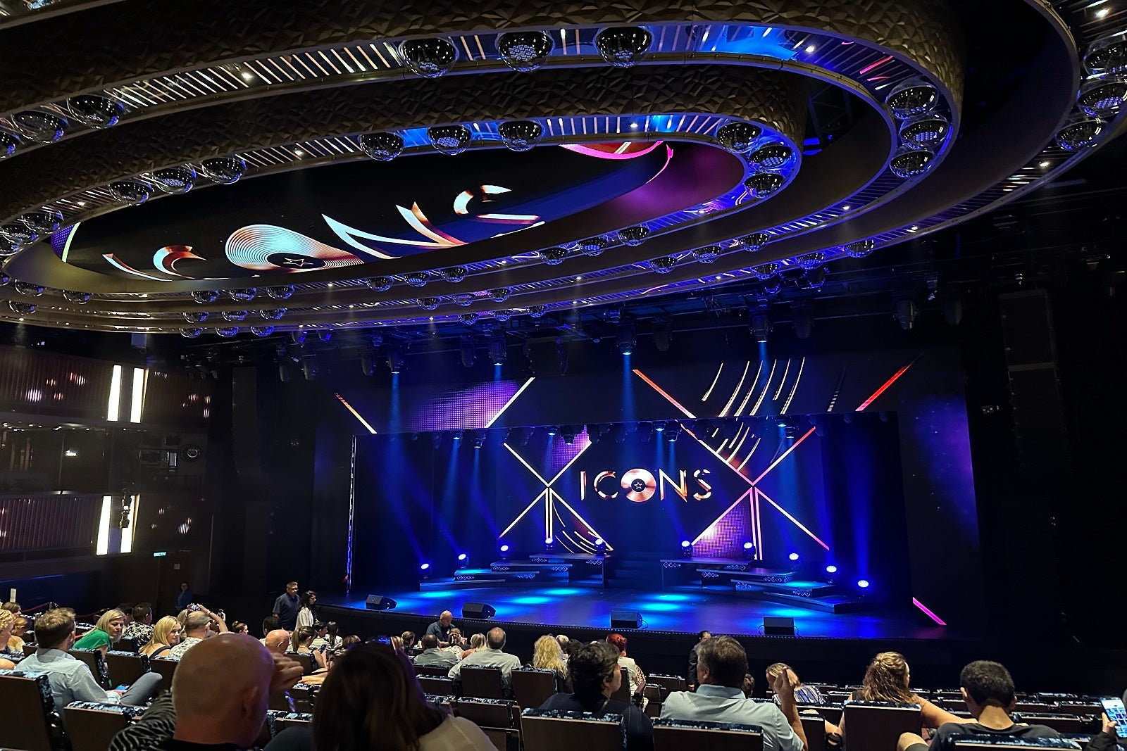 The stage in a cruise ship theater with the words "Icons"