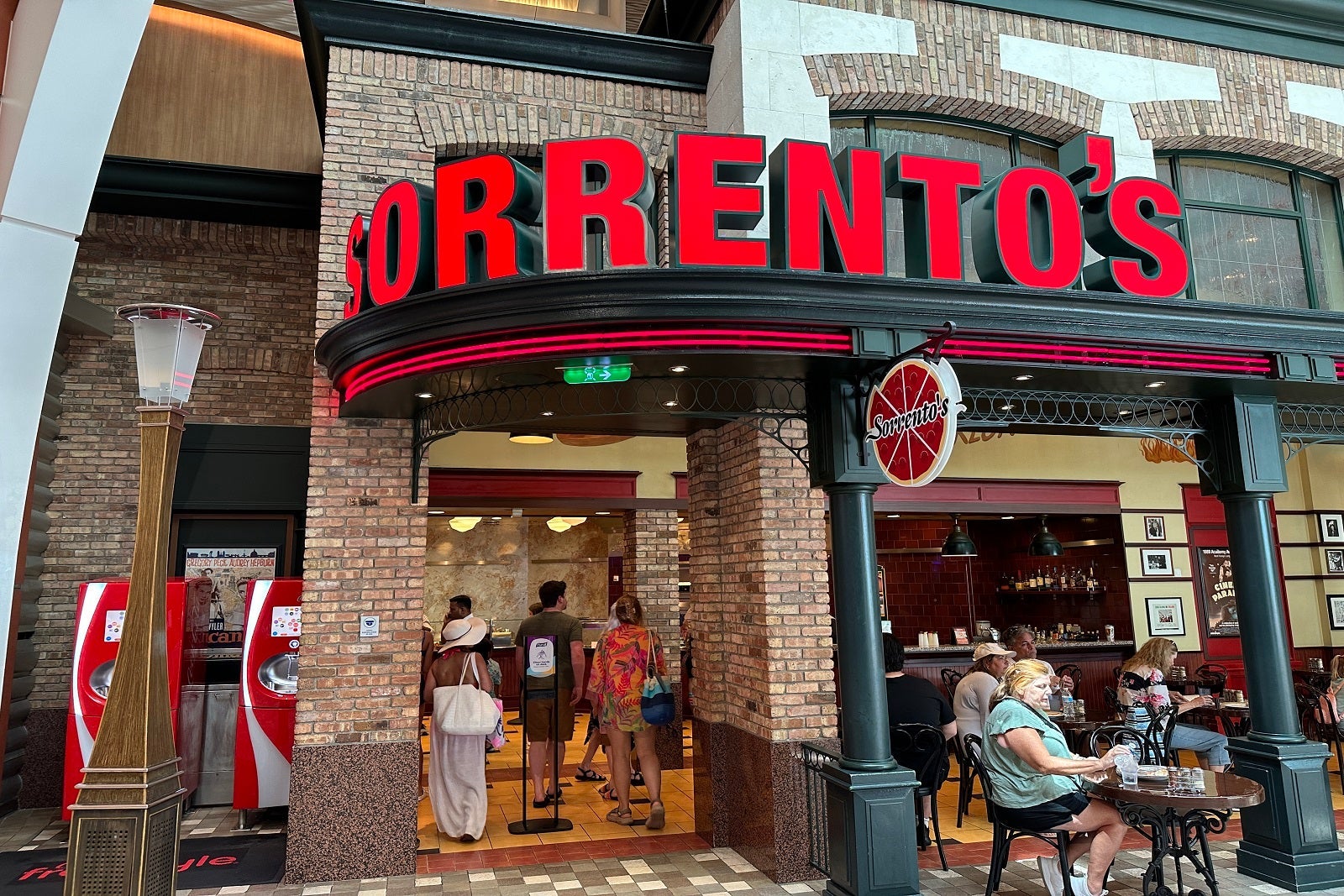 A brick pizza restaurant on a cruise ship with large red sign on the front that says "Sorrento's"