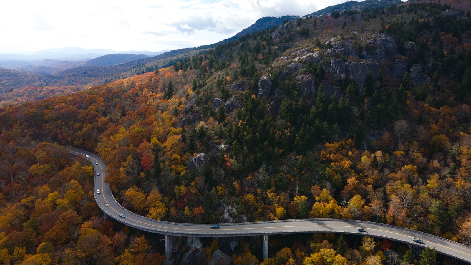 Aerial of a Winding Highway Through a Forest in Autumn