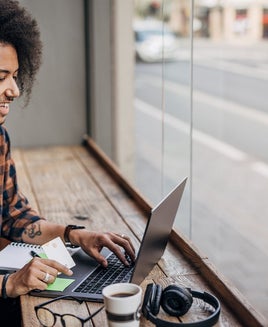 A man using a laptop near a window