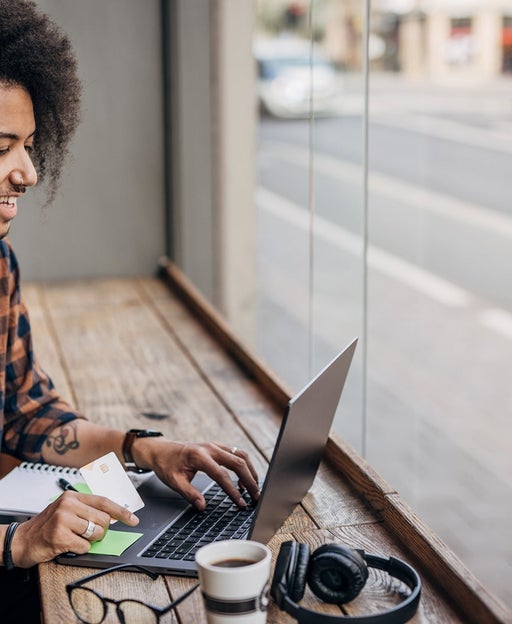 A man using a laptop near a window