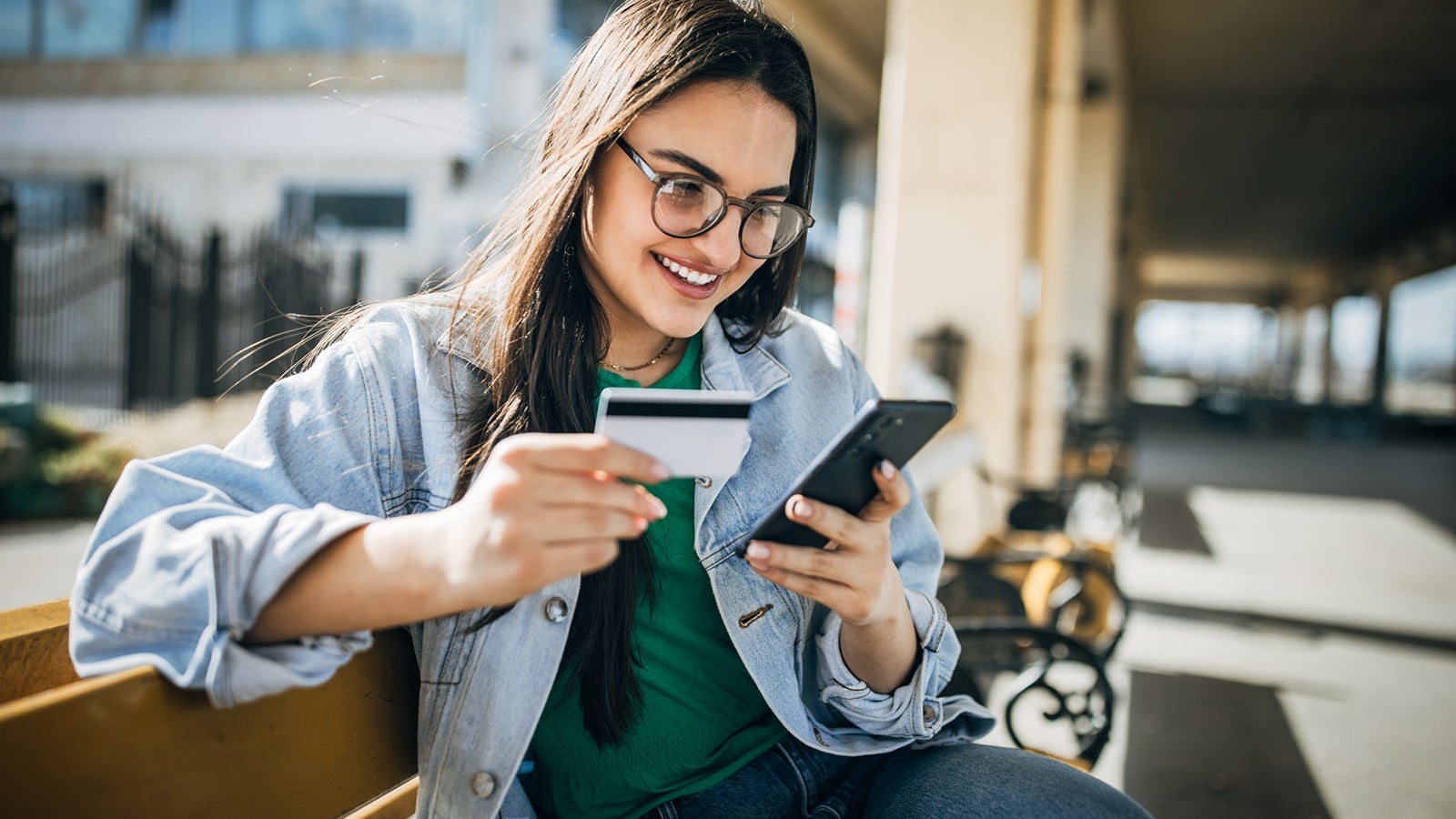Young woman online shopping at home on mobile phone n the railway station