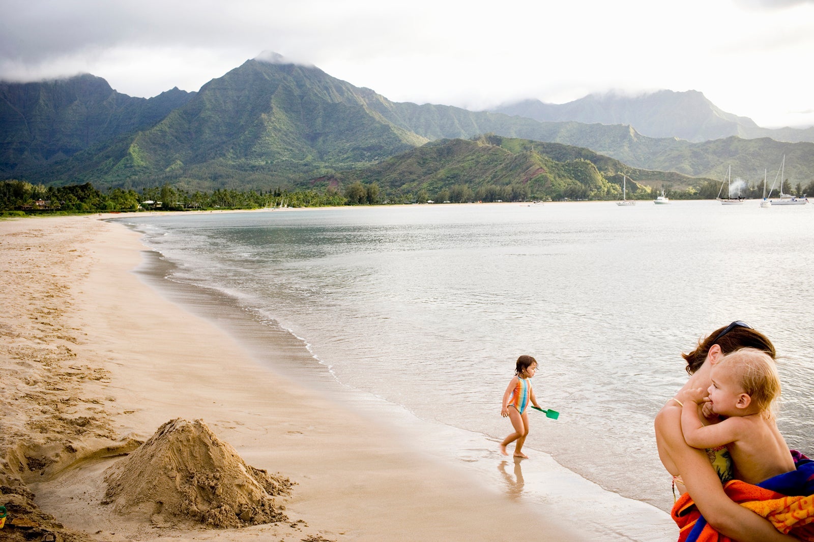 Family plays on beach in Hawaii