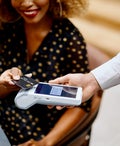 Businesswoman paying for the order contactless with a black credit card