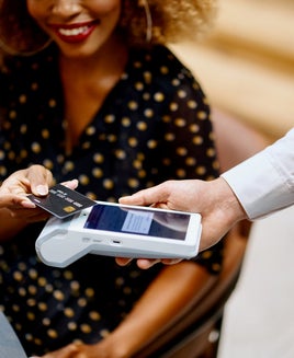 Businesswoman paying for the order contactless with a black credit card