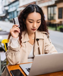 Young woman in cafe after shopping using credit card for online shopping