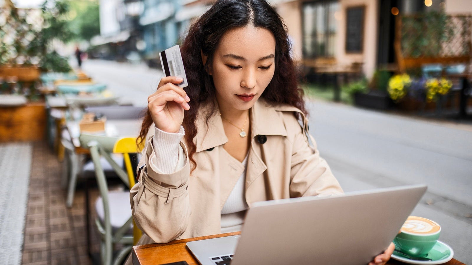 Young woman in cafe after shopping using credit card for online shopping