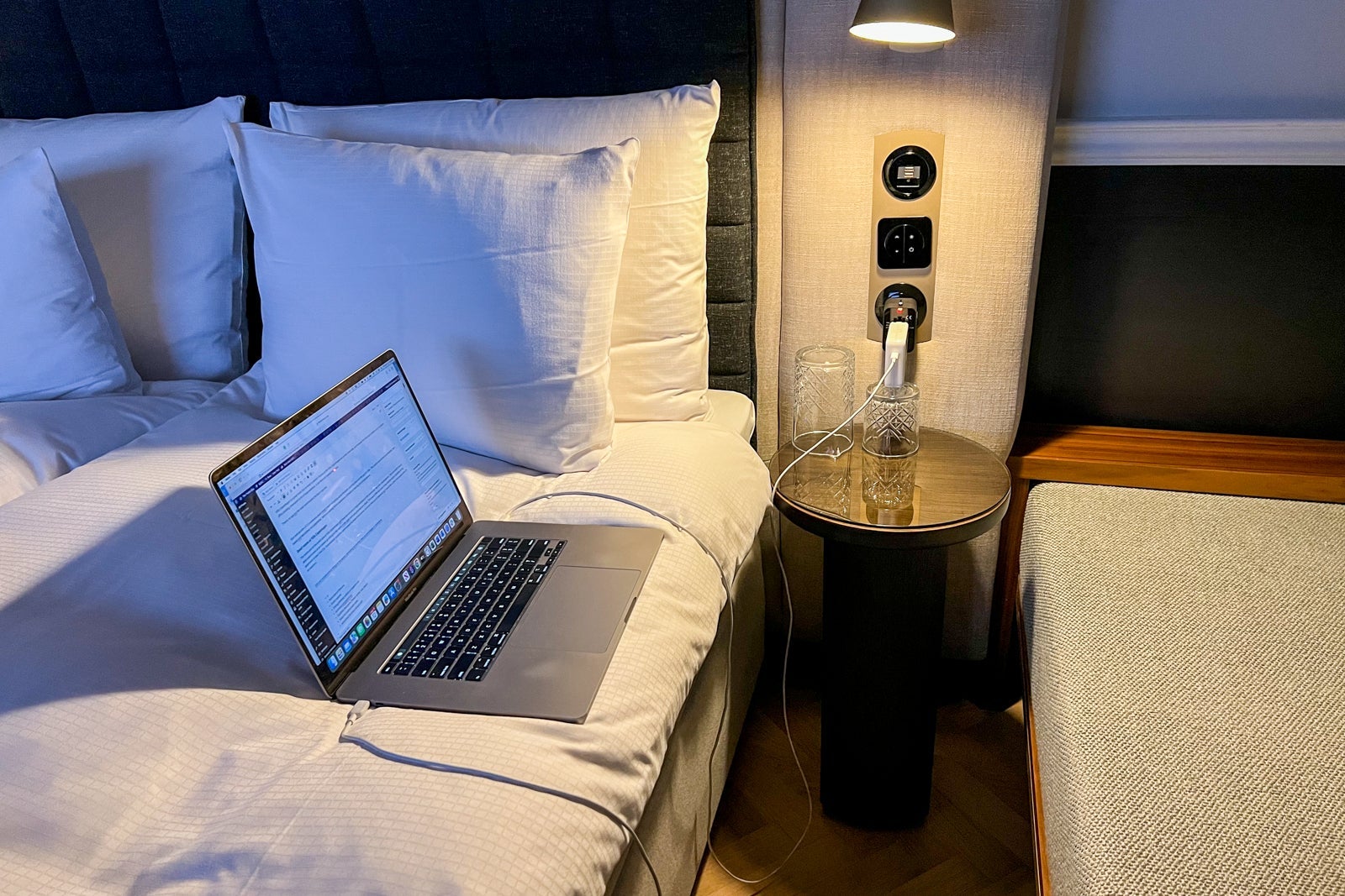 charger and laptop on hotel bed