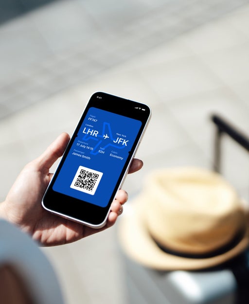 Close-up of female hand holding smart phone with boarding pass