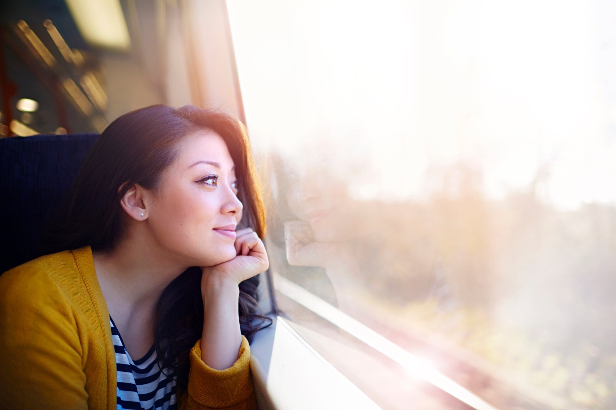 Woman on a train day dreaming out the window.