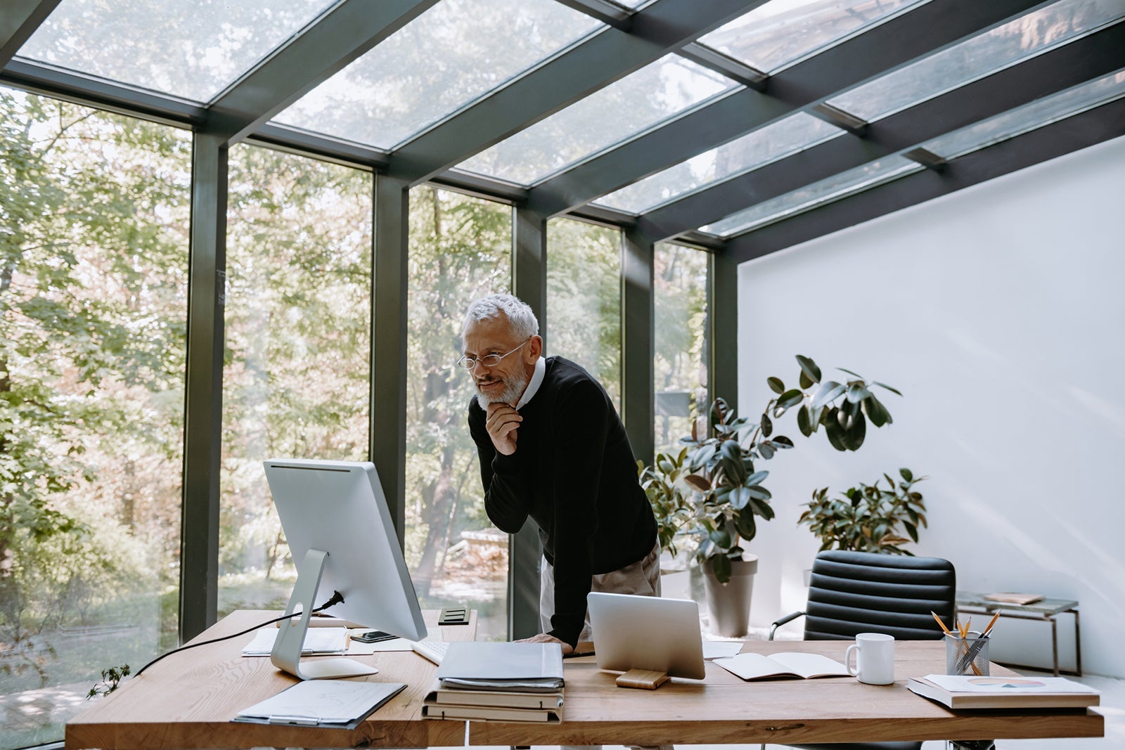 A man looking at a computer in a sun room