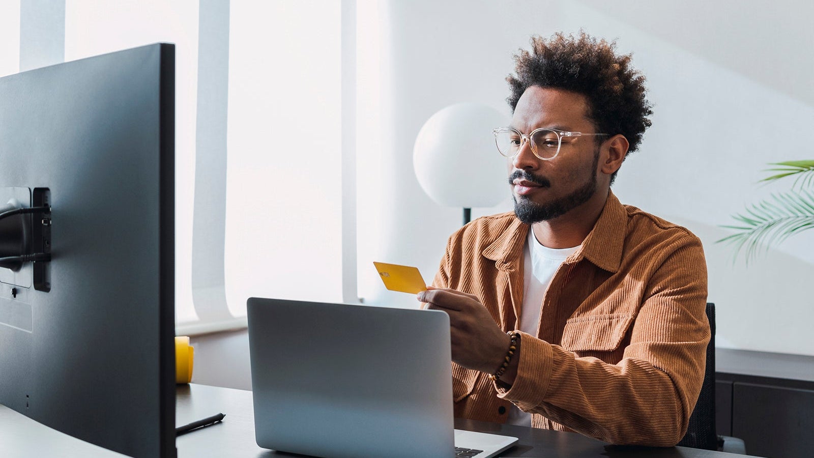 Businessman with credit card sitting at office
