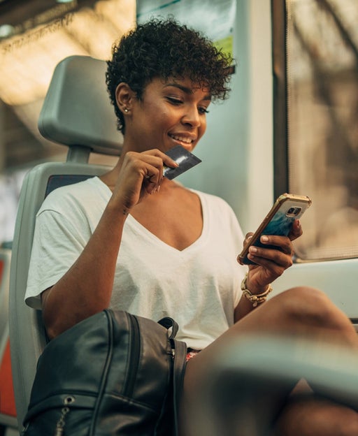 woman holding credit card and using mobile phone