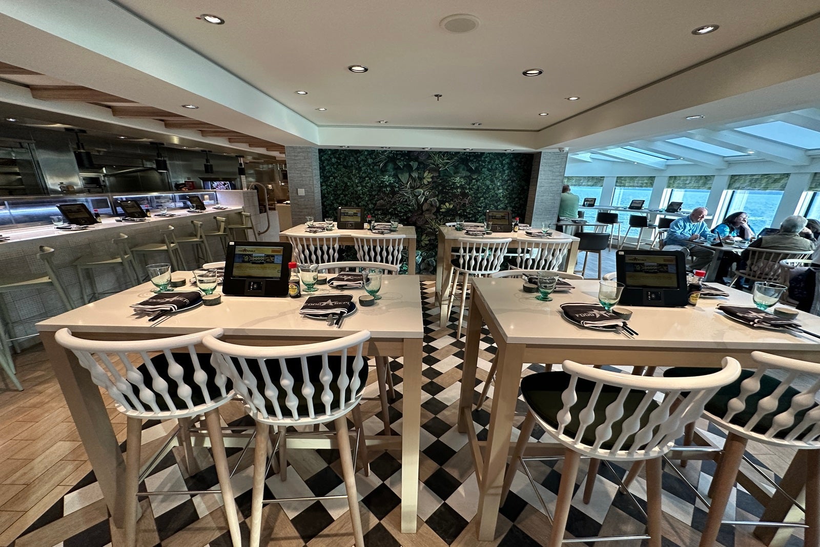 A restaurant with tables, chairs and a sushi counter