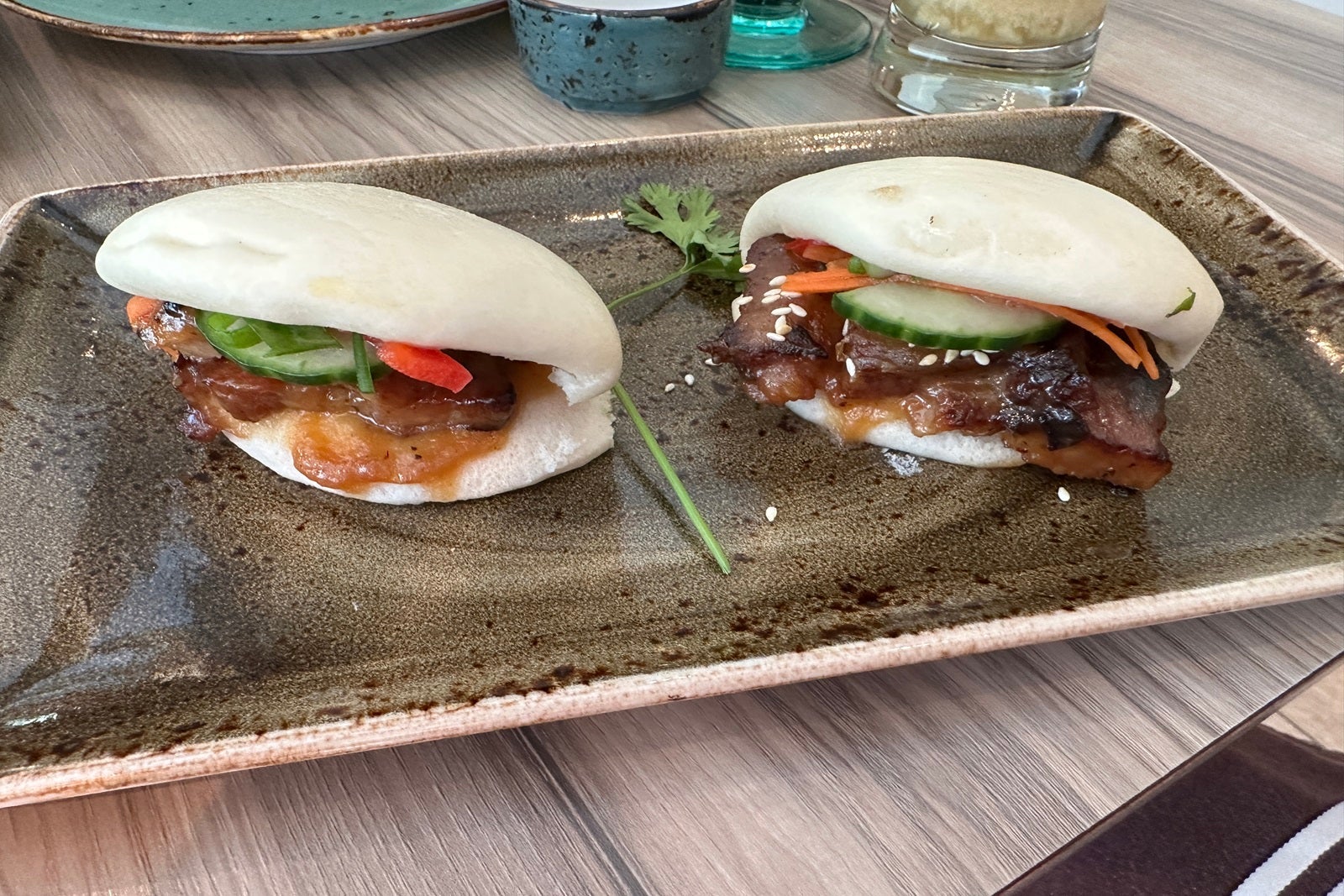 A table with two pork bao buns on a plate