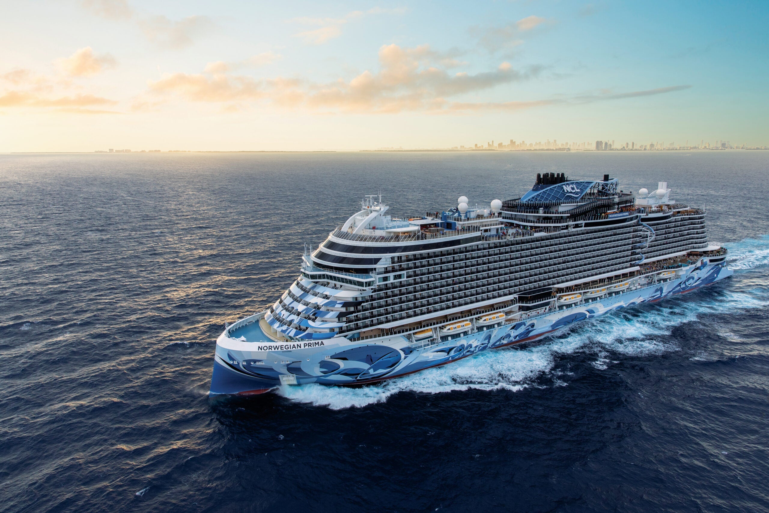 Norwegian Prima cruise ship in the ocean with Miami skyline in the distance