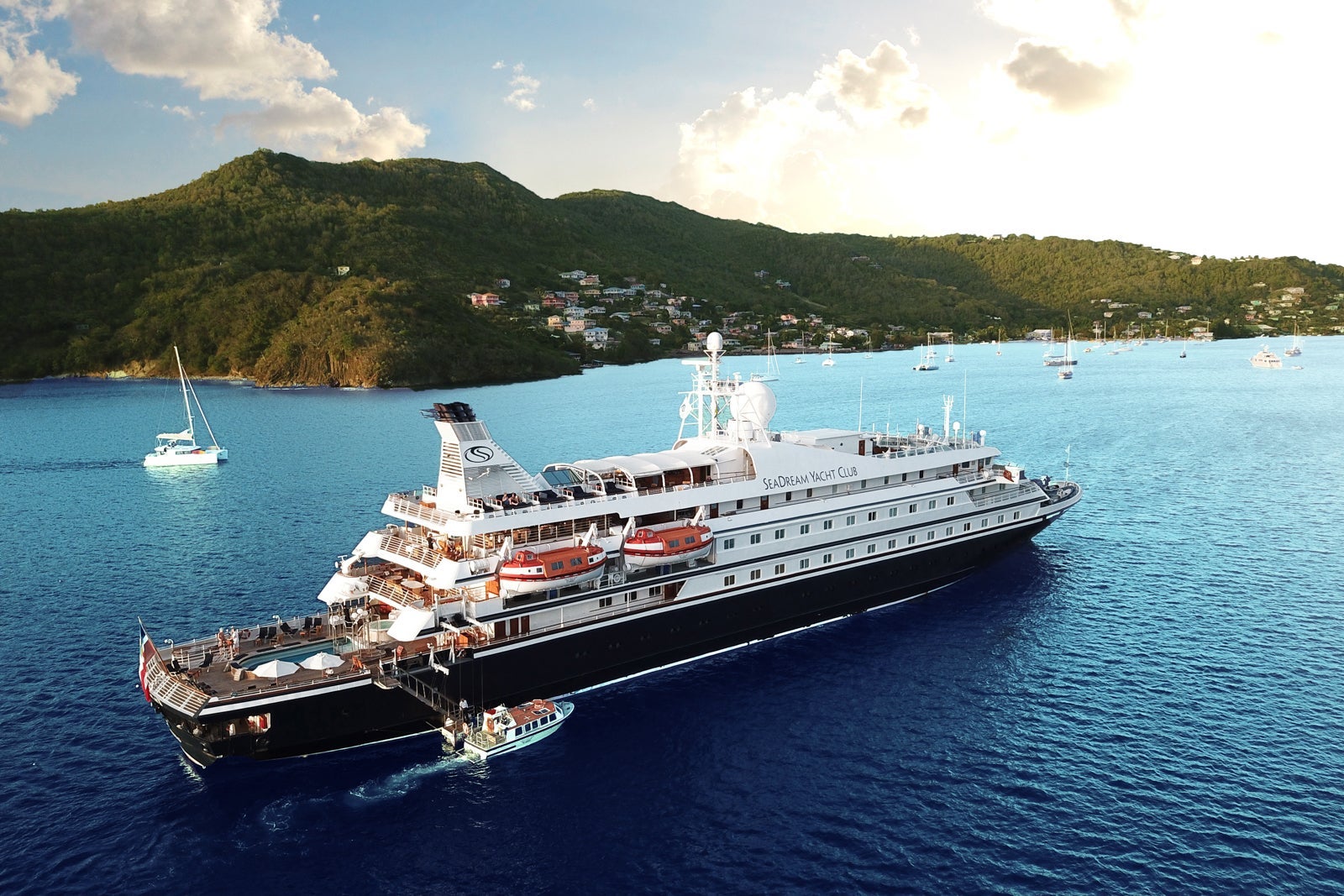 A small cruise ship anchored in front of small mountains