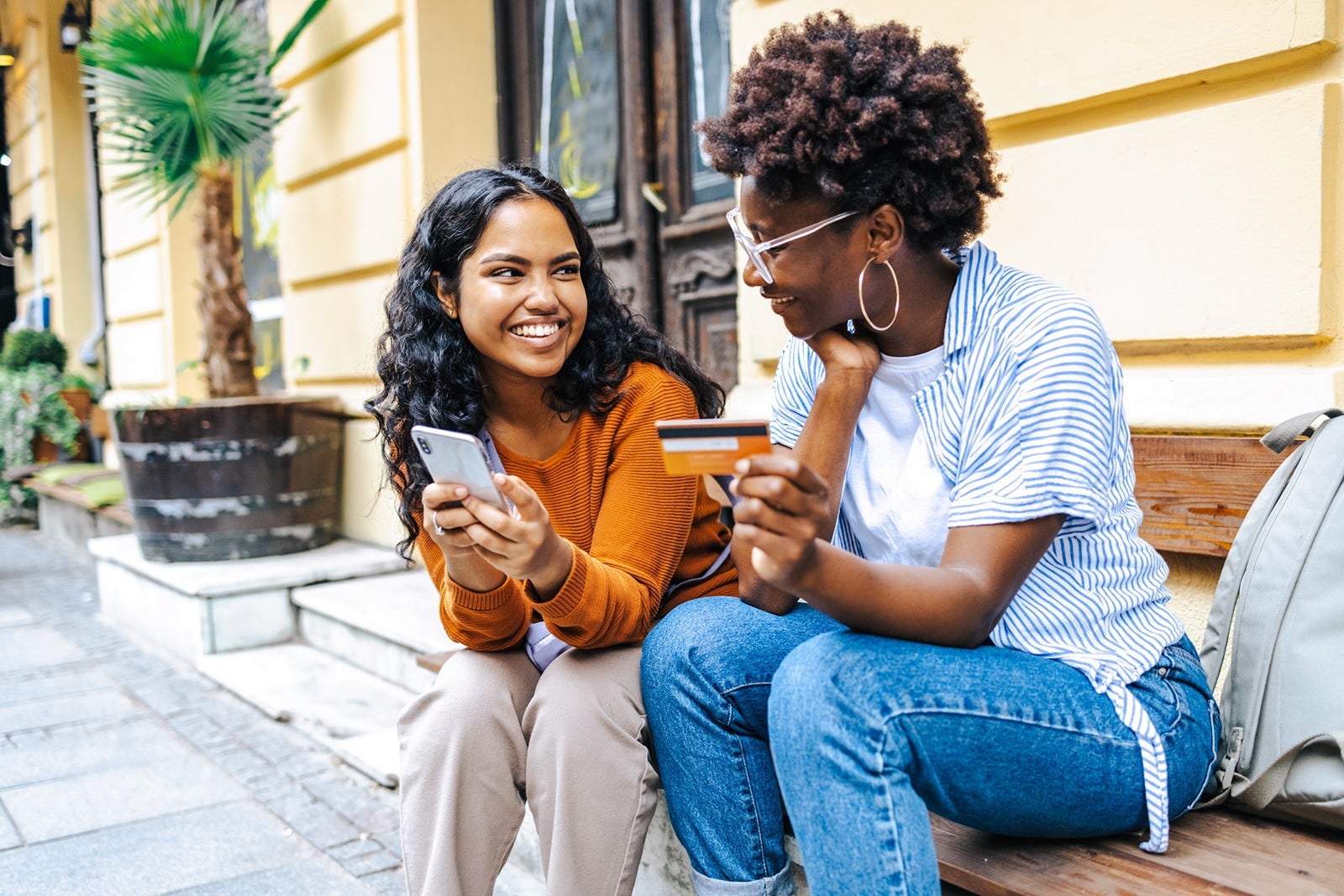 Two people holding a credit card