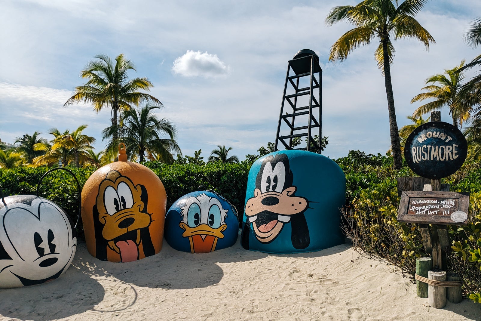Round rocks painted with Disney character faces on tropical island