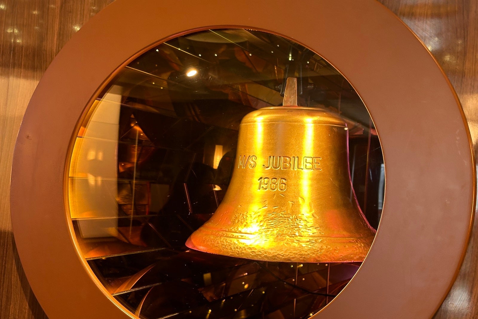 A ship's bell in a protective case, displaying the name of the original MS Jubilee