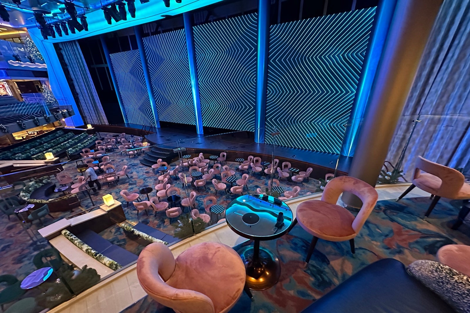 An aerial view of a stage with LED panels and lots of pink chairs