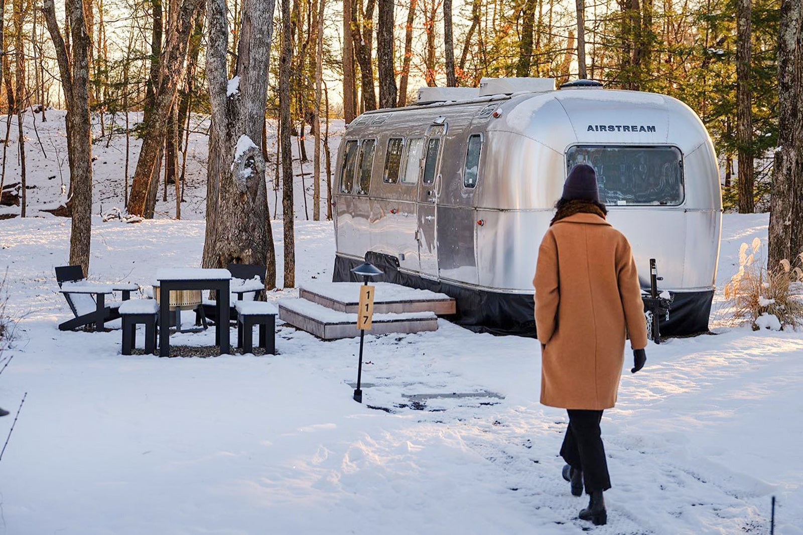 Guest walks to camper in the snow at Autocamp resort