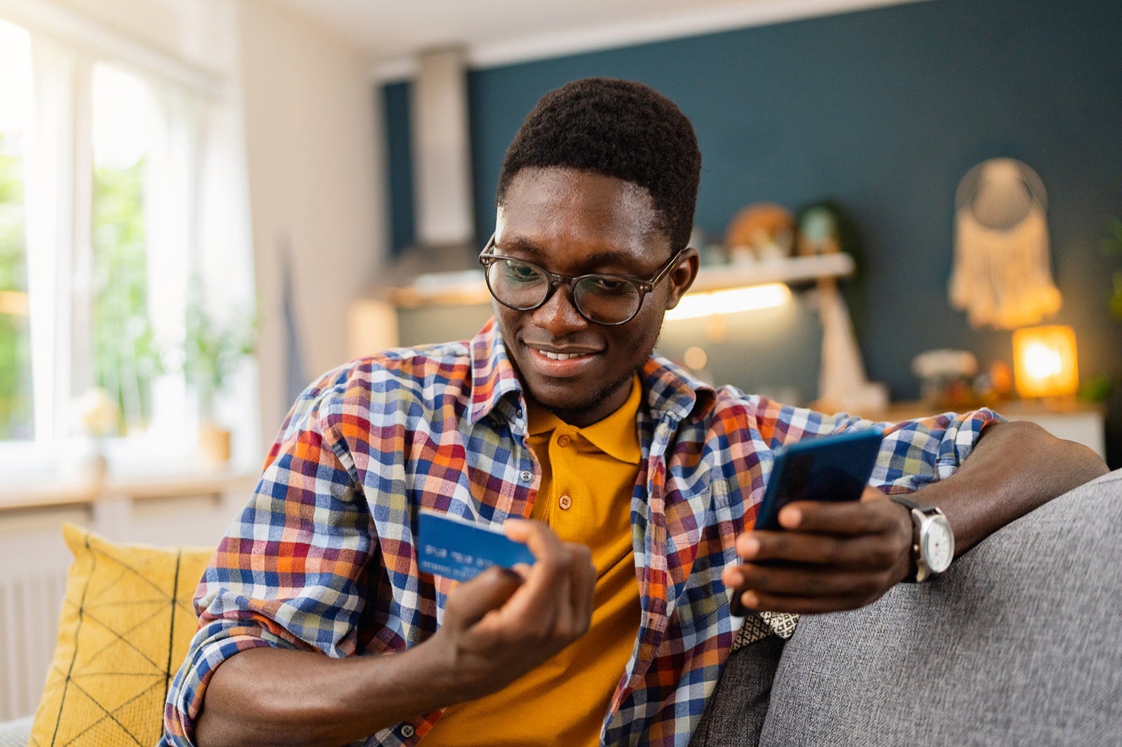 A person using a phone while holding a credit card