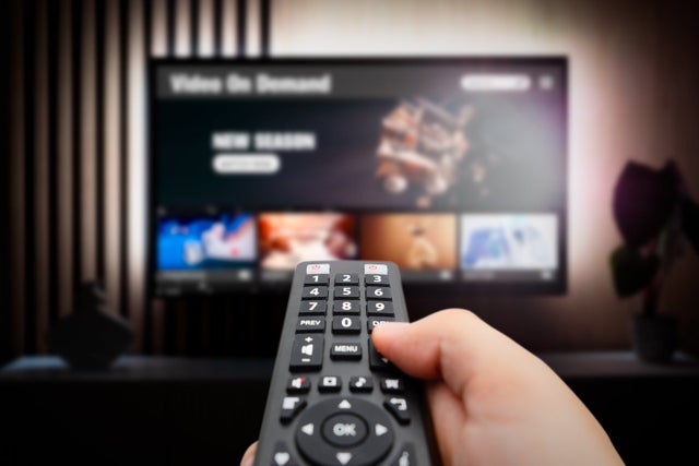Person pointing a remote at the T.V.