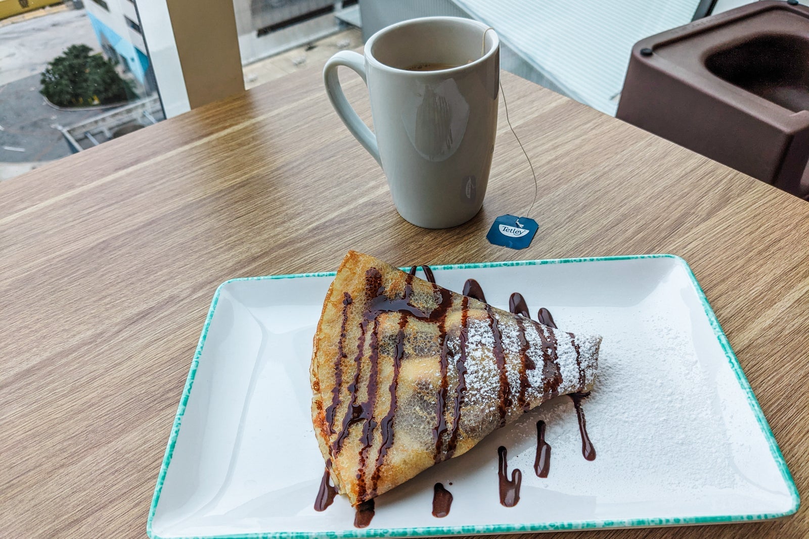 Chocolate crepe and white mug of tea