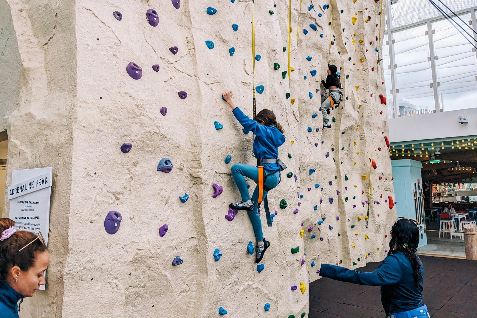 Girl climbing rock wall on cruise ship