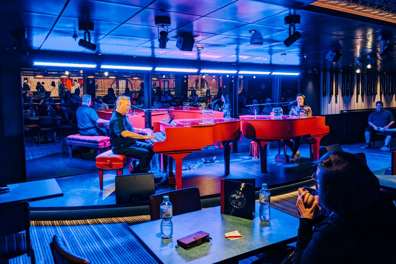 Dueling Pianos bar with two red pianos with a male and female pianist
