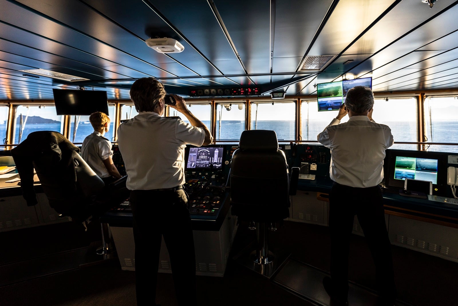 A cruise ship captain and officers keeping watch on the bridge