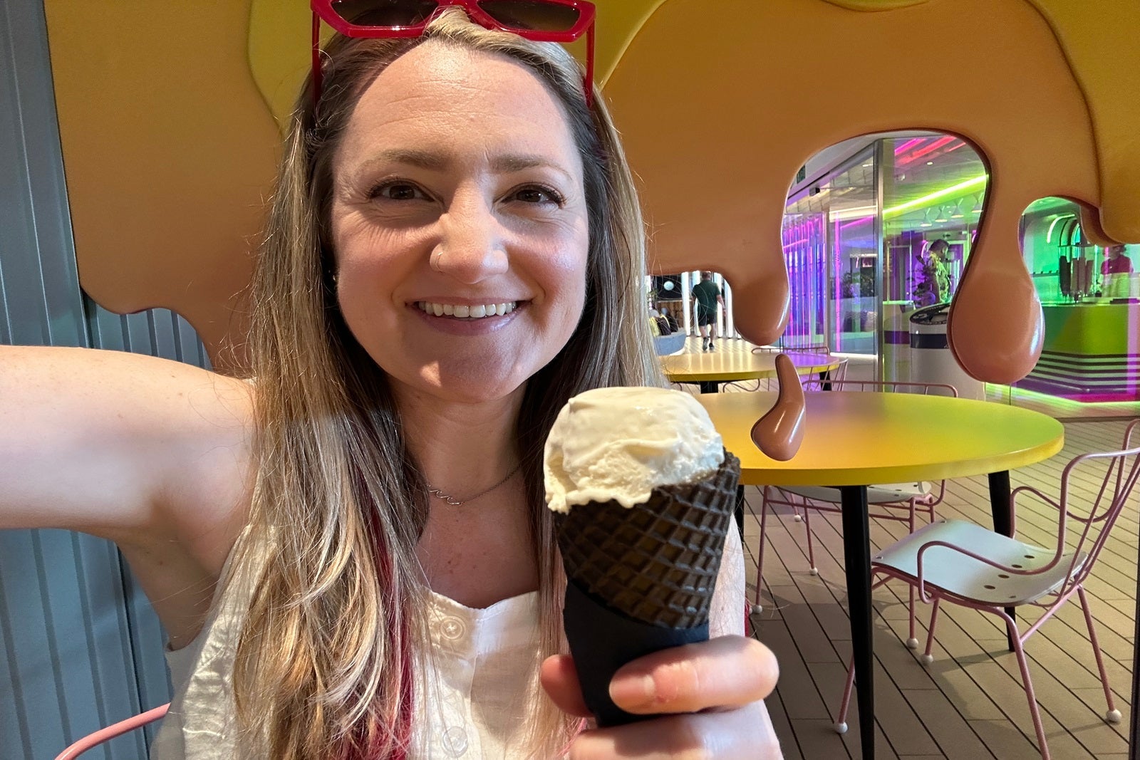 A woman holding a chocolate cone with a scoop of ice cream