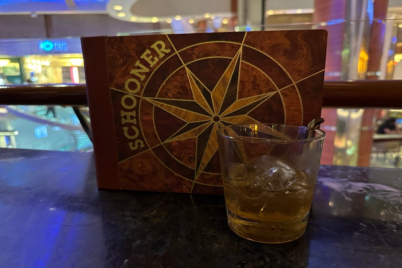 A cocktail in front of a Schooner Bar menu