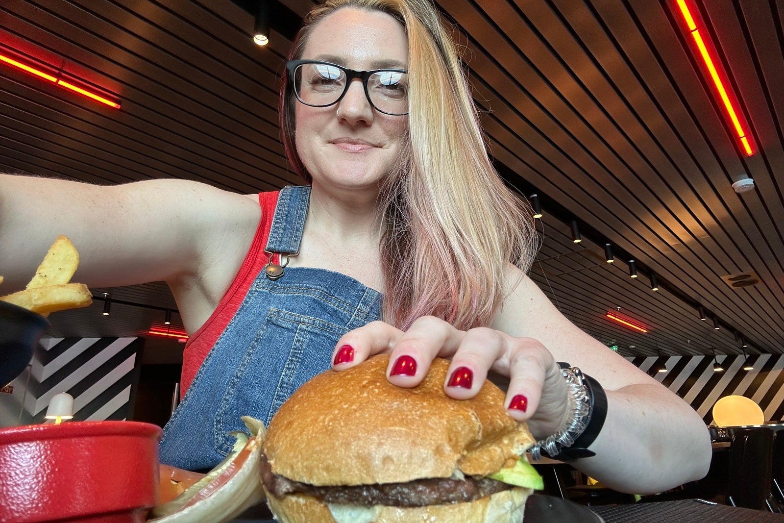A woman holding a cheeseburger