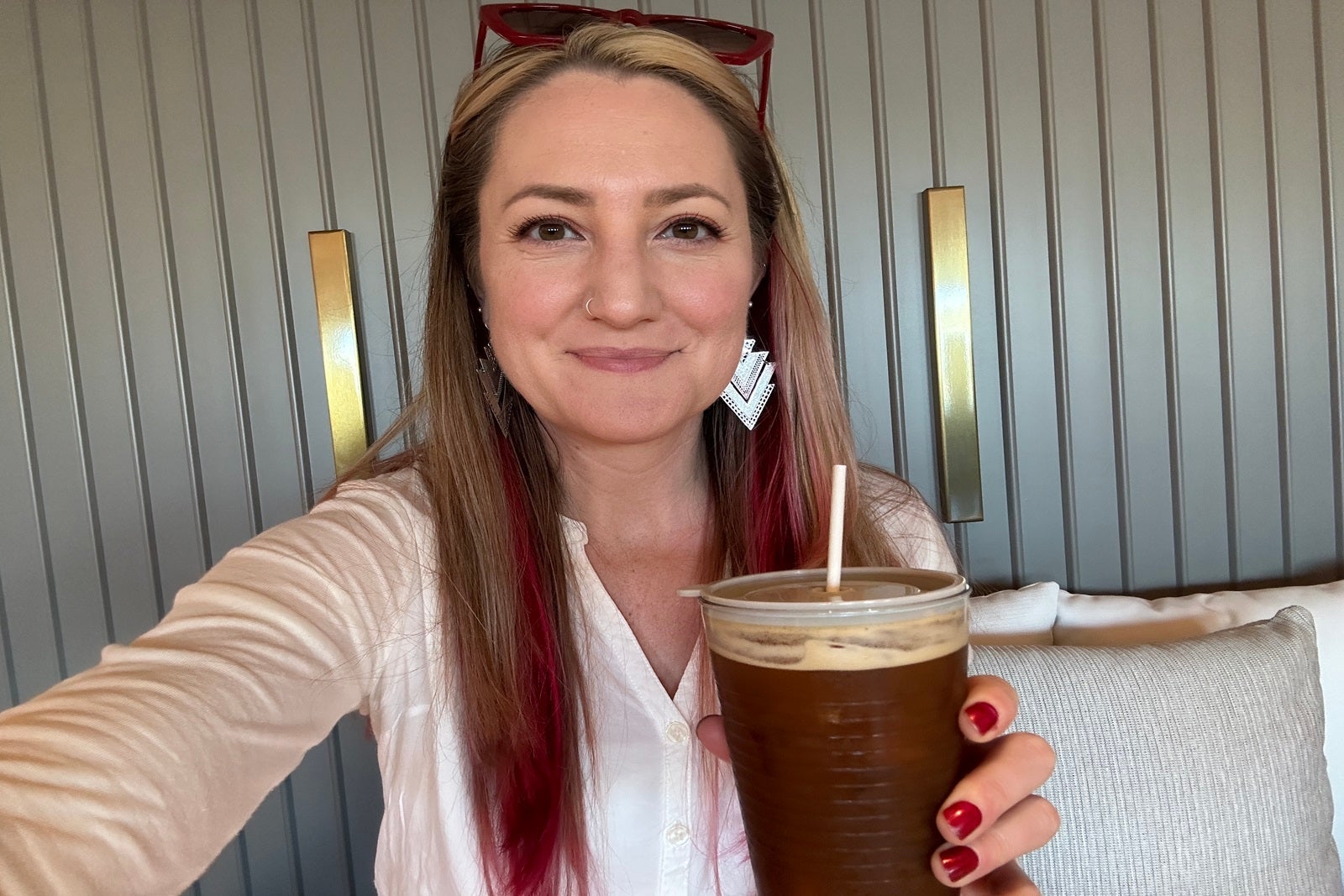 A woman holding an iced coffee
