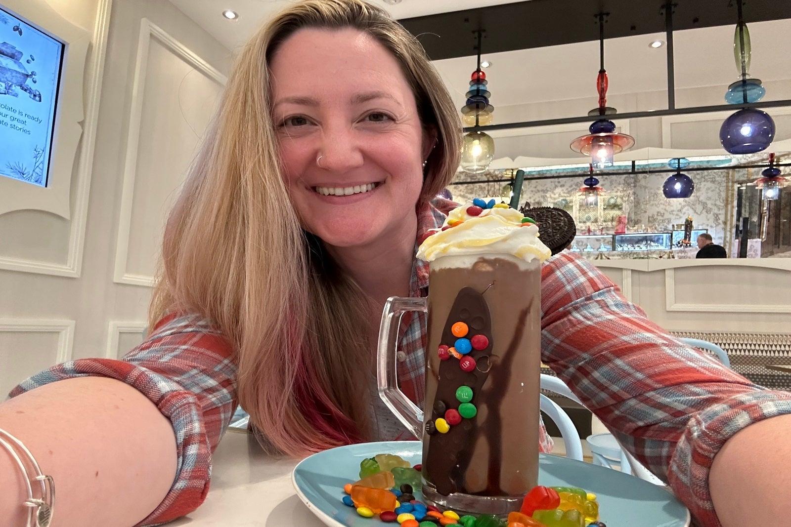 A woman with a milkshake covered in candy