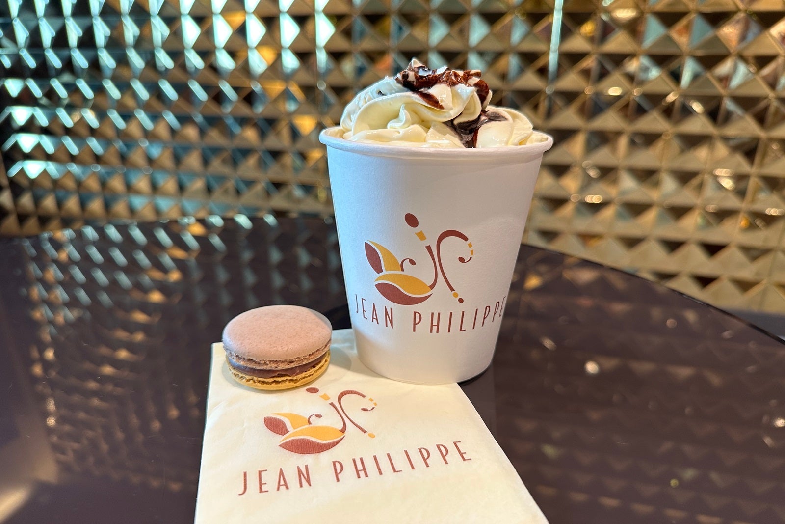 A napkin with a macaron and a cup of coffee