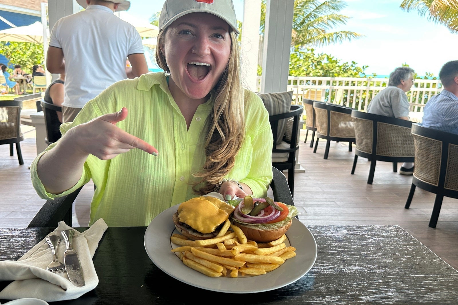 A woman pointing excitedly at a cheeseburger