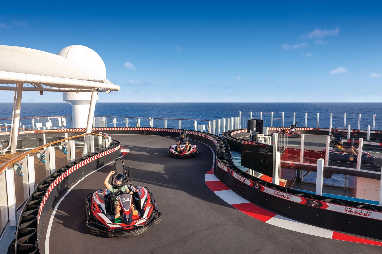 Passengers race go-karts on a cruise ship
