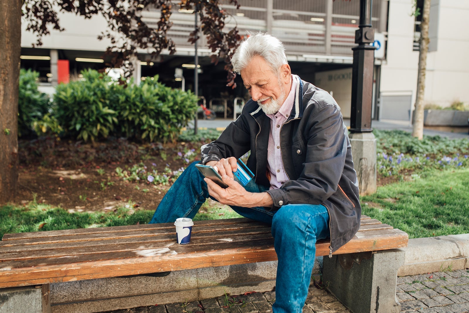 Man with a credit card on a bench