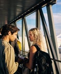 Young adult couple embarking on a weekend vacation, boarding the plane on the runway.
