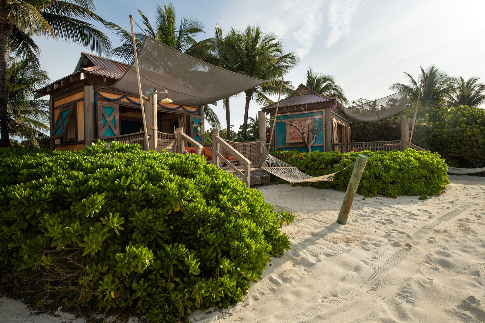 Exterior view of beach cabana with bush and hammock out front