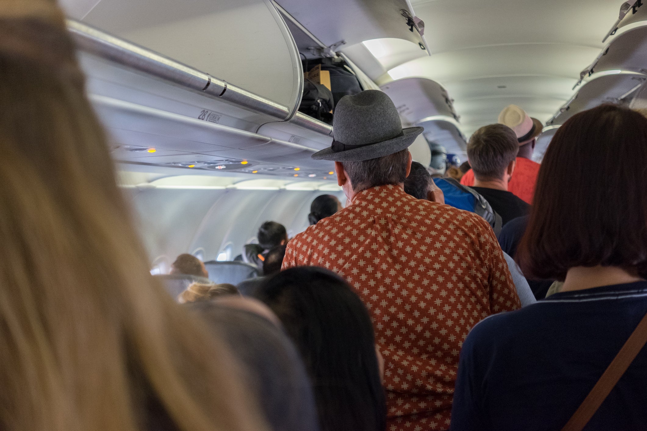 Passengers disembarking aircraft on arrival, back view