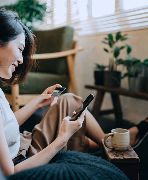 Woman using a smart phone and credit card
