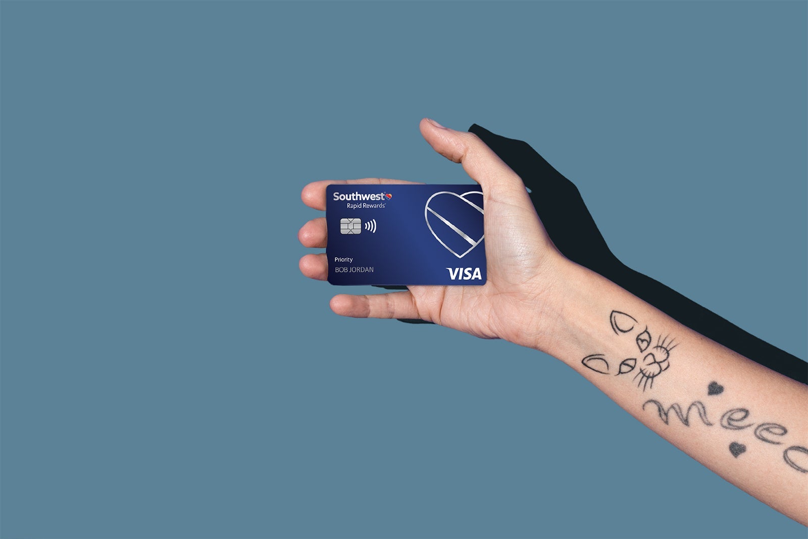 A hand holding Southwest Rapid Rewards Priority card